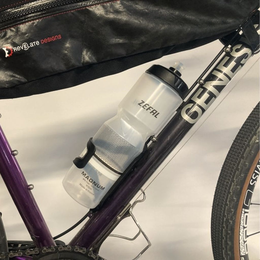 Porte-bidon à entrée latérale installable dans les deux sens, idéal pour les vélos gravel équipés de sacoches de cadre en cyclotourisme.
