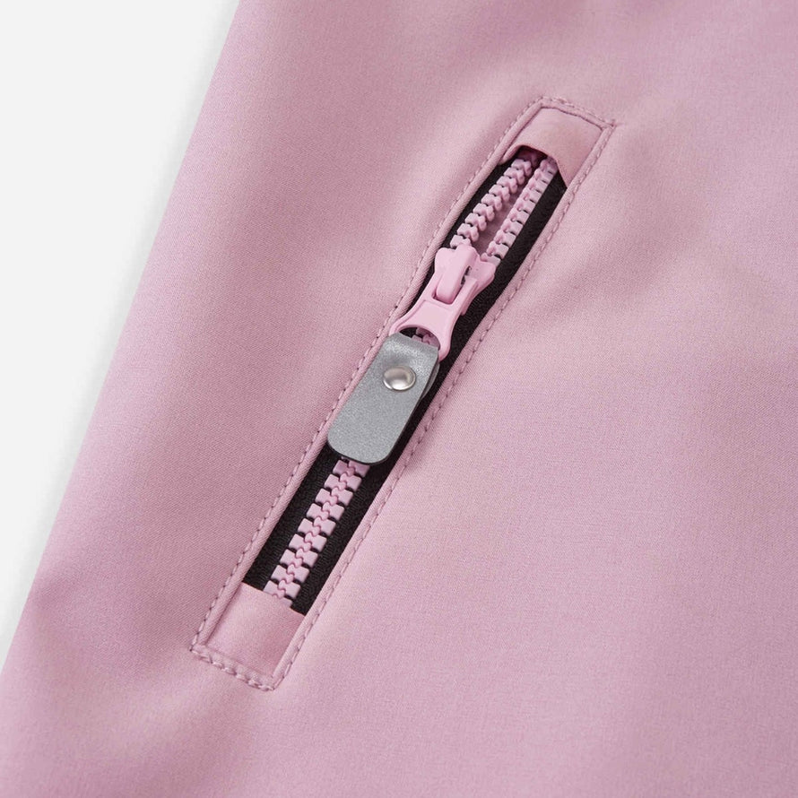 Détail fermeture éclair rose de la combinaison softshell enfant Reima Mjosa, résistante et adaptée aux activités outdoor