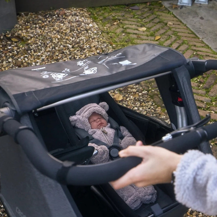 Remorque vélo modulaire Yuuna Croozer avec bébé confortablement installé en extérieur