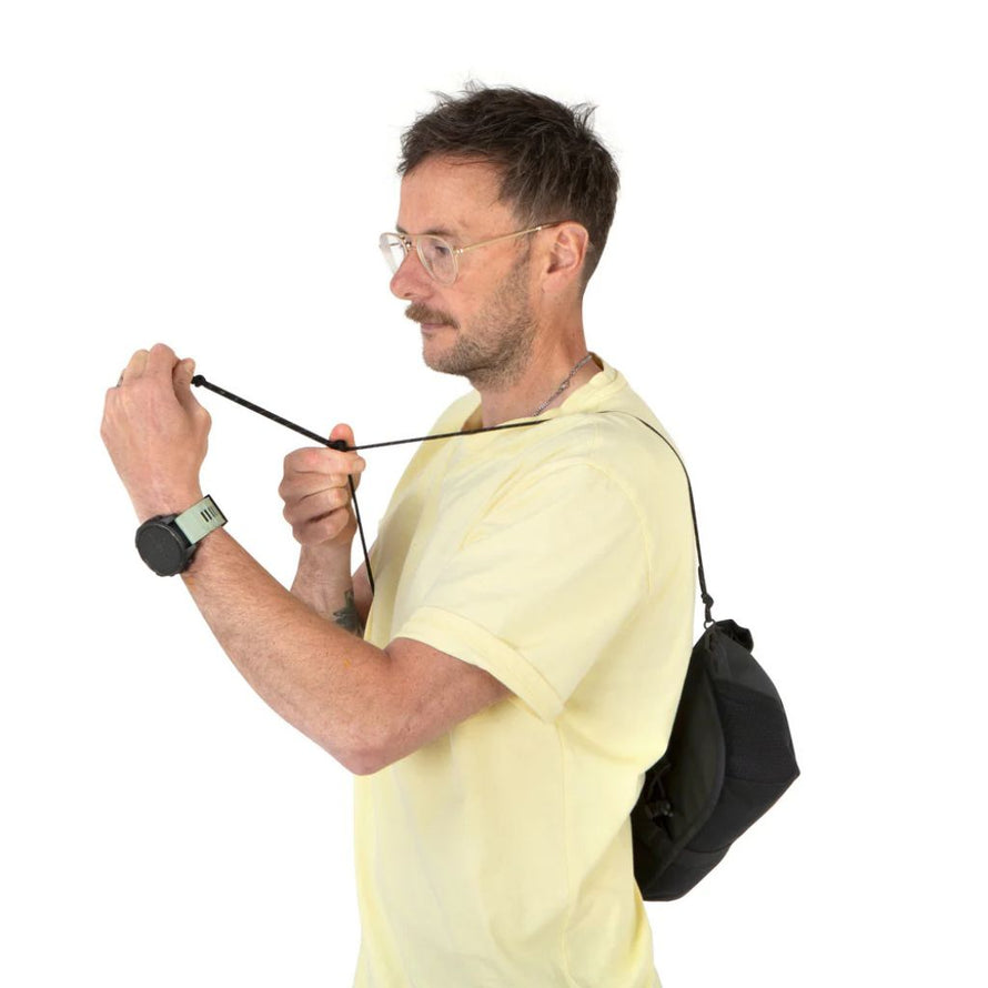 Sacoche Canister Restrap portée à l’épaule grâce à sa sangle en paracorde.