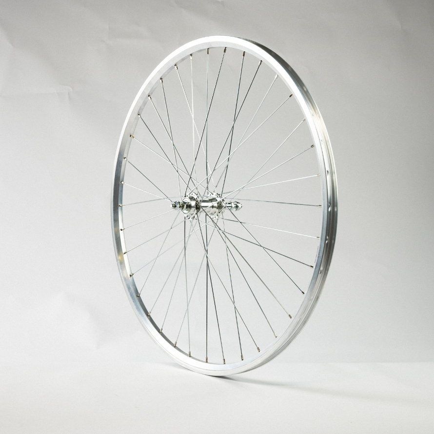 Vue latérale de la roue arrière 28 pouces argentée, mettant en évidence l’axe fileté et la jante métallique.