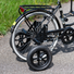 Vue de profil d’un vélo adulte équipé de roues stabilisatrices arrière, fixées de part et d’autre de la roue principale.