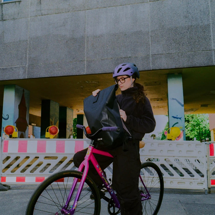 Femme cycliste avec sac a dos etanche Ortlieb Velocity TIDURA strong 23L noir en usage urbain