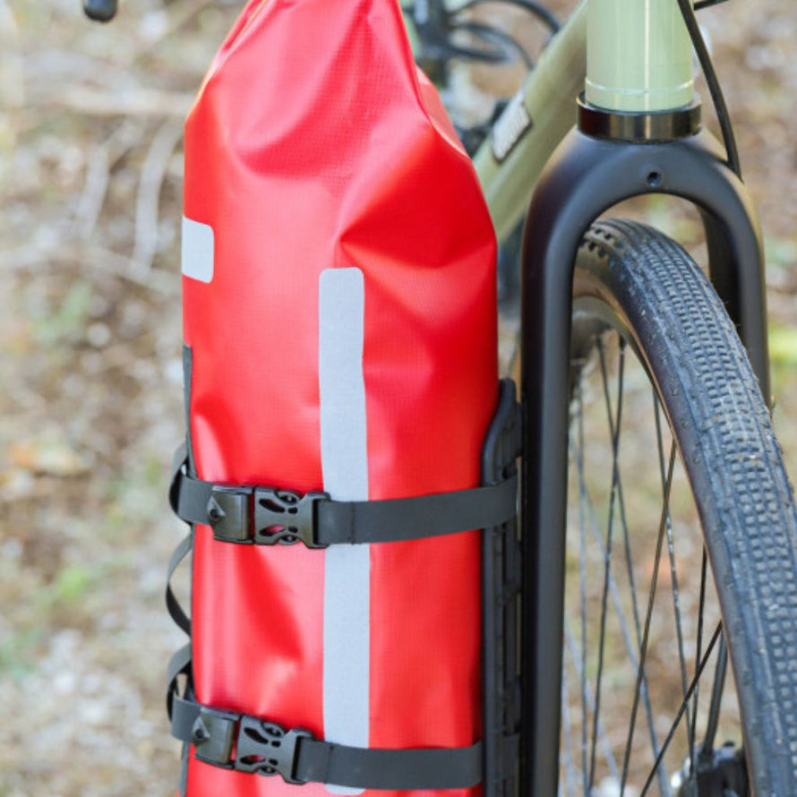 Sac étanche Zéfal rouge fixé verticalement sur la fourche d’un vélo