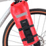 Sac étanche Zéfal rouge attaché à la fourche avant d’un vélo sur fond clair