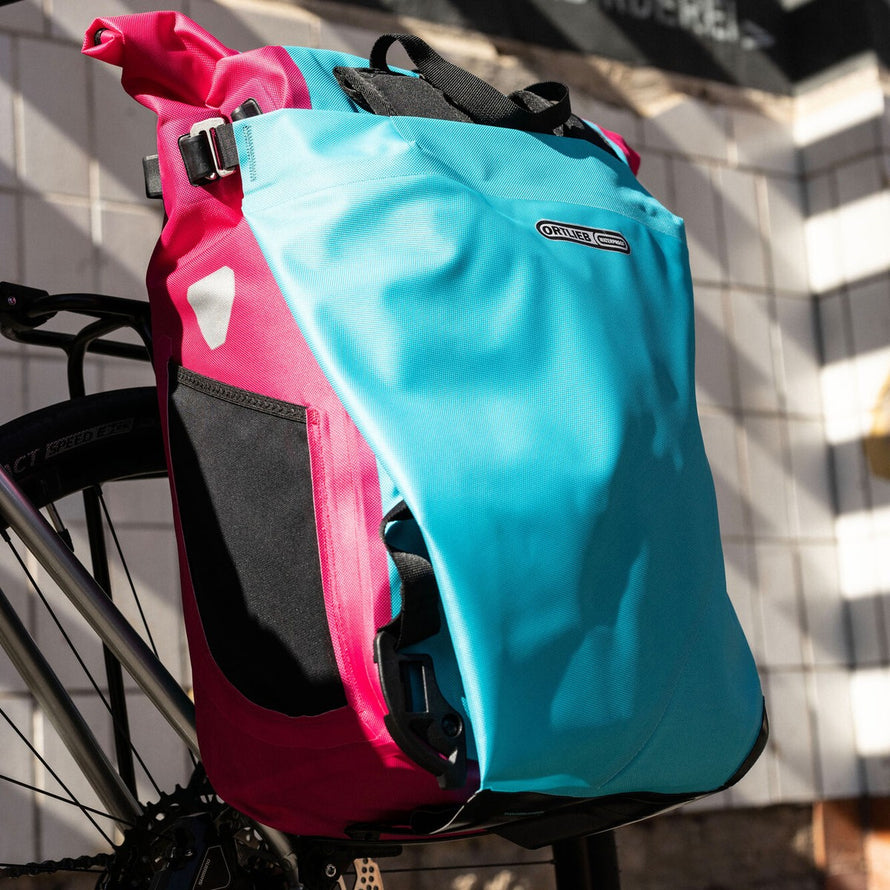 Sacoche vélo convertible sac à dos Vario Ortlieb fixée sur porte-bagages en bleu et rose
