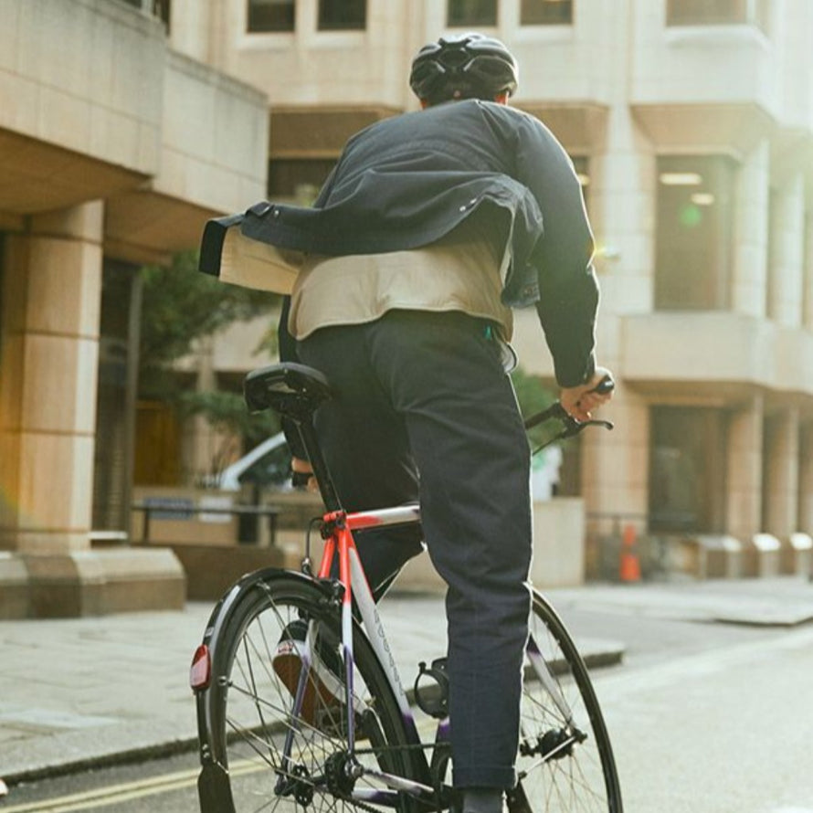 Homme pédalant en danseuse en ville avec une selle vélo réfléchissante Vivo Moderate Selle Royal. 