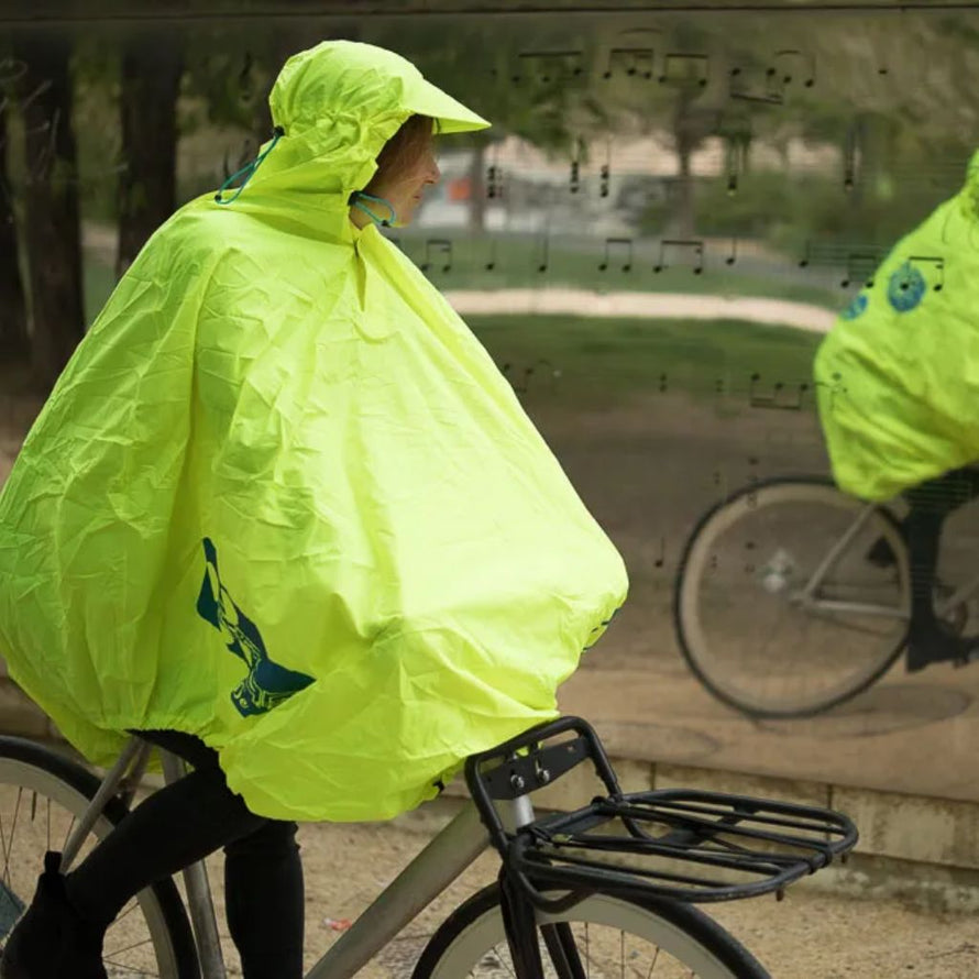 Poncho de pluie conçu pour les cyclistes, avec forme couvrante, serrage et visière prévus pour un trajet entièrement sec