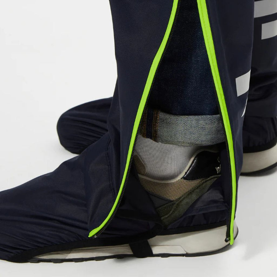 Détail du zip étanche du pantalon de pluie Urban Circus Iyuc facilitant l’enfilage avec des chaussures.