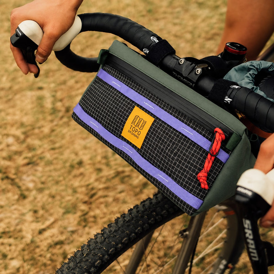 Sac porte-gourde Topo Designs Mountain Hydro Sling 950 ml fixé sur guidon VTT pour sorties nature