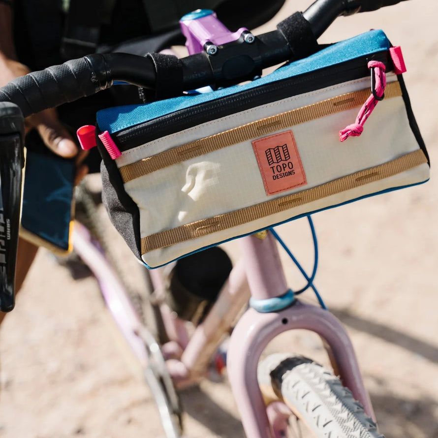 Pochette porte-gourde Topo Designs Mountain Hydro Sling 950 ml fixée sur guidon vélo pour sorties urbaines et trail