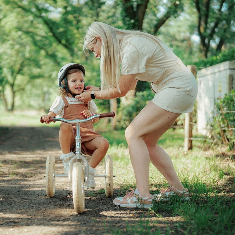Enfant avec casque sur draisienne evolutive 2-en-1 Urban Iki beige transformable en tricycle en plein air