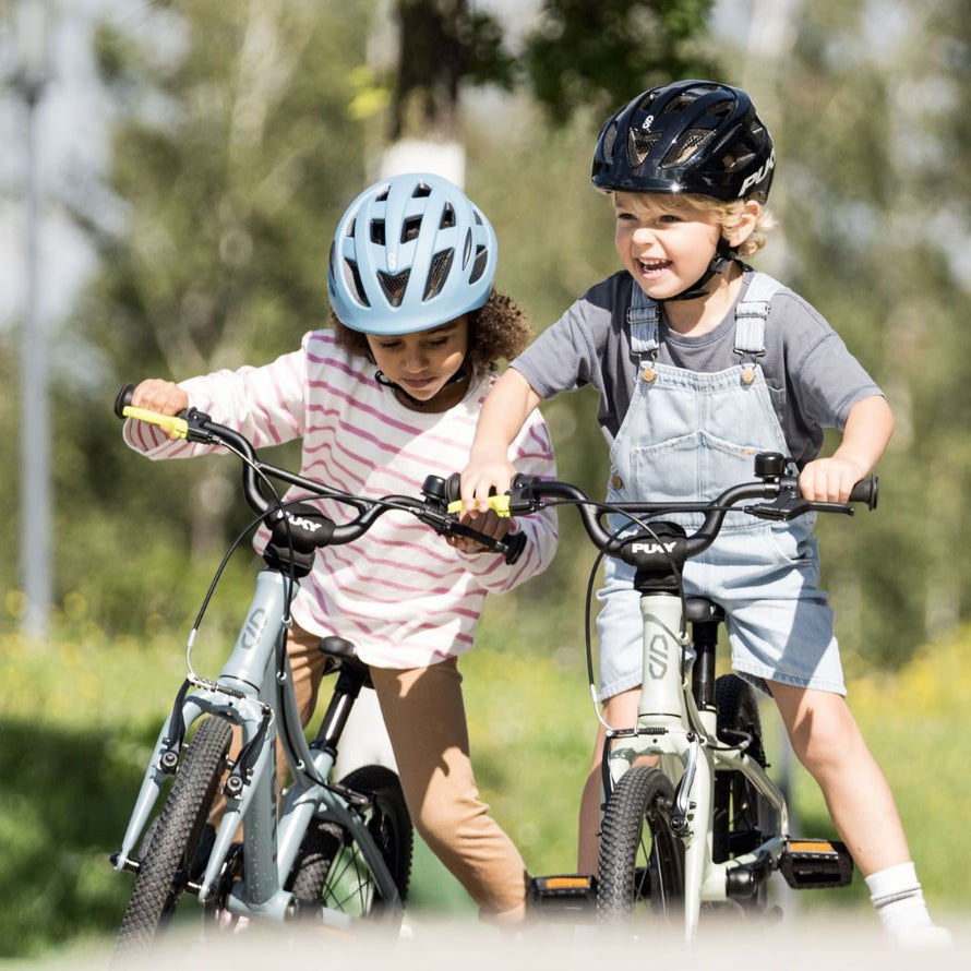 Deux enfants s’amusent avec leurs vélos PUKY LS-PRO 14 dans un skatepark, casque et sécurité au rendez-vous