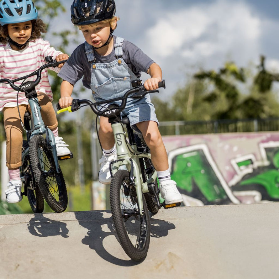 Deux enfants portent un casque et roulent en toute sécurité sur leur vélo PUKY LS-PRO 14 tout-terrain
