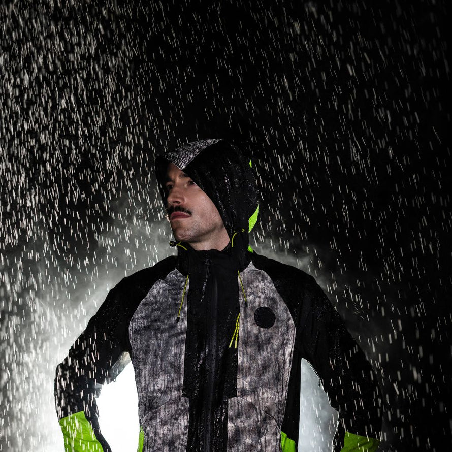 Cycliste portant la veste réfléchissante Wowow Etna, vêtement technique et respirant pour vélo, offrant une visibilité maximale sous la pluie.