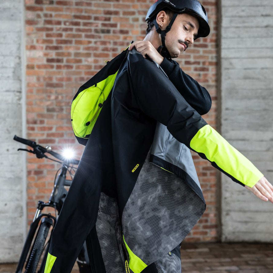 Cycliste en veste Wowow Etna fluo, équipement étanche et respirant pour une visibilité maximale à vélo.