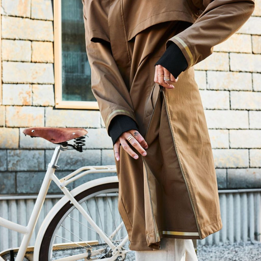 Gros plan sur la veste Imbris camel, détail du panneau latéral zippé pour faciliter le mouvement en pédalant.