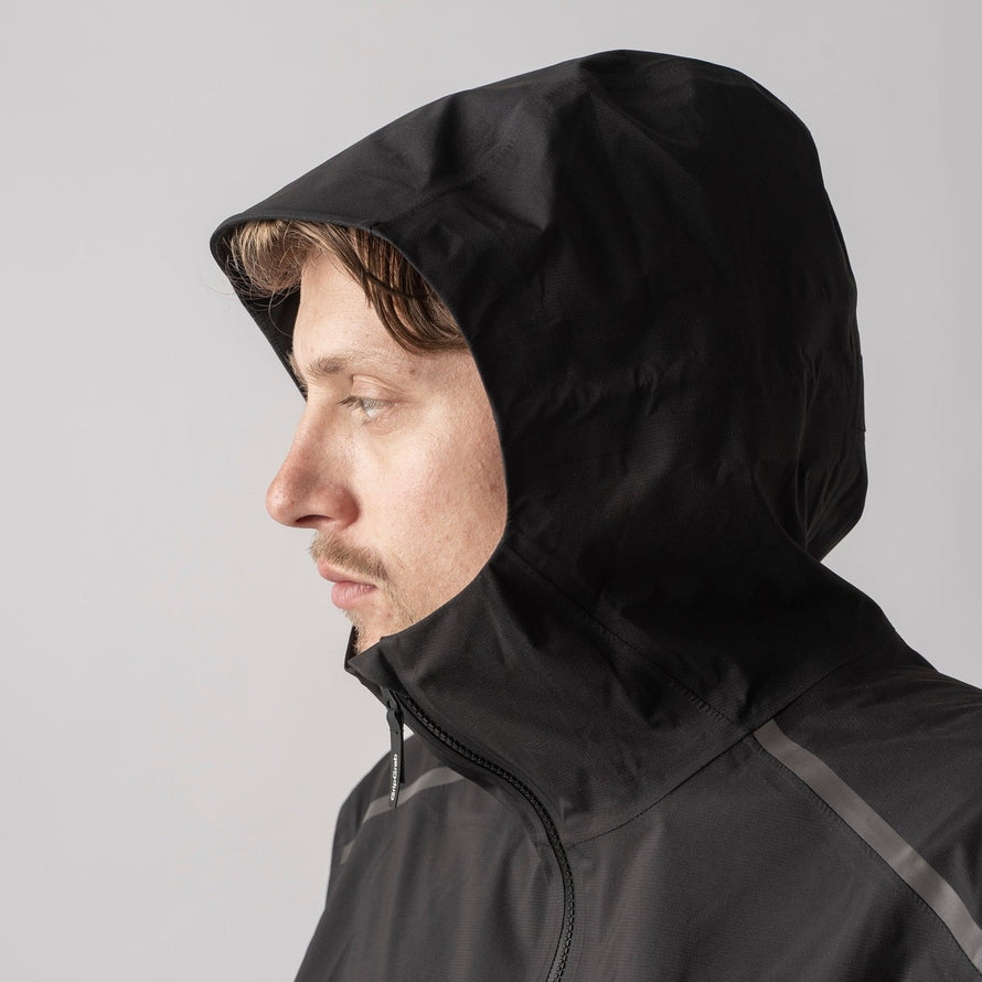 Profil homme avec veste vélo imperméable Explr GripGrab noire et capuche, protection pluie optimale