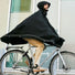 Homme roulant à vélo avec le poncho noir Imbris Weathergoods Sweden, protection imperméable et coupe-vent.