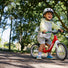 Enfant souriant avec casque sur draisienne rouge Woom GO 1 pour 18 mois a 3.5 ans en plein air