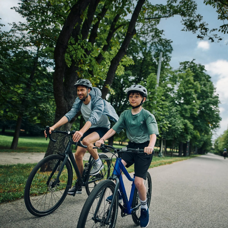 Enfant de 6 à 8 ans sur vélo woom explore 4 20 pouces bleu en balade en plein air avec casque
