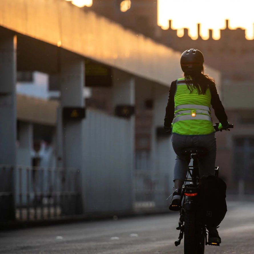 Cycliste en ville avec lampe led magnetlight 2.0 de la marque wowow fixee sur une veste de securite